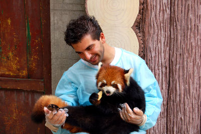 Portrait of man with red panda
