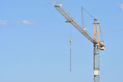 Low angle view of crane against sky