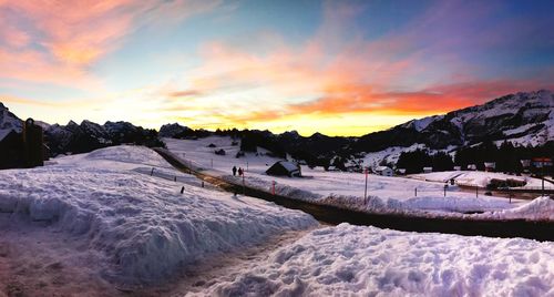 Scenic view of snow covered landscape against sky during sunset