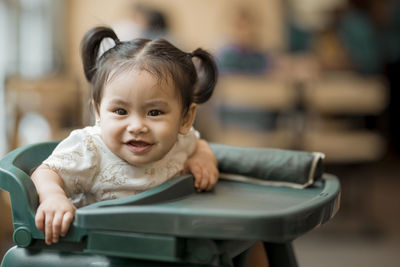 Cute girl sitting on high chair