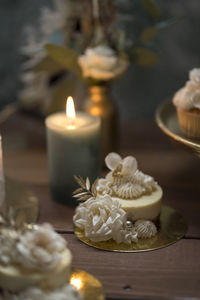 Close-up of burning candles and sweets on table