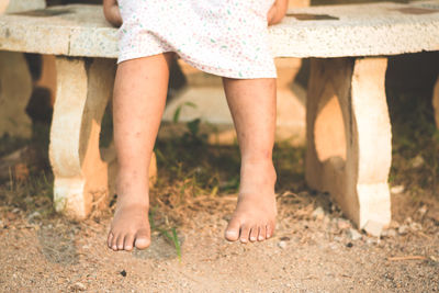 Low section of girl sitting on bench