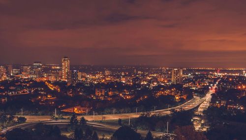 Illuminated cityscape against sky at night