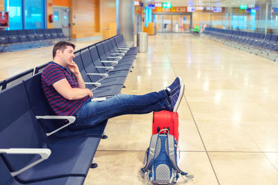 Full length of young man sitting on chair