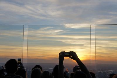 People photographing against sky during sunset