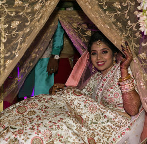 Portrait of a smiling young woman lying on bed