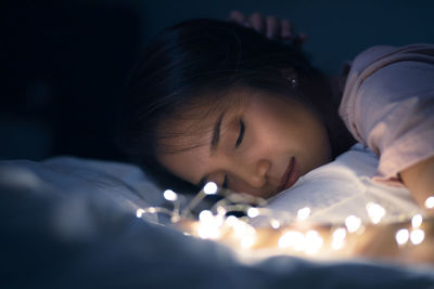 Close-up portrait of young woman sleeping in bed