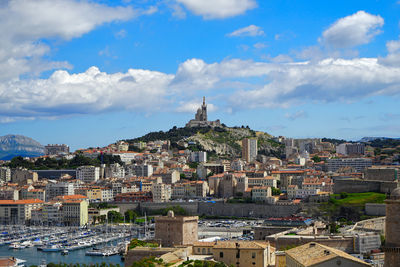 Buildings in city against cloudy sky