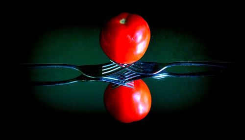 Close-up of tomatoes on table against black background