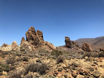 Rock formations against clear blue sky