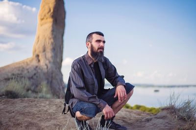 Full length portrait of young man against sky