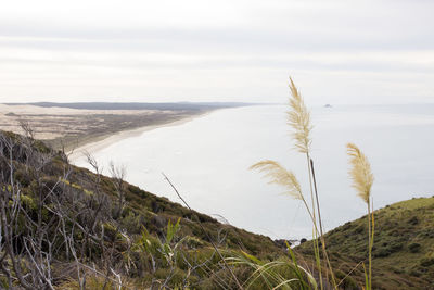 Scenic view of land and sea against sky