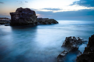 Rock formation on sea against sky