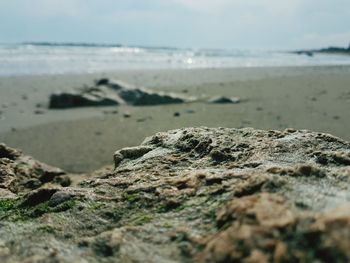 Close-up of sand at beach against sky