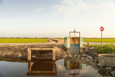 Built structure on paaddy field against sky