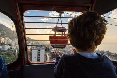 Rear view of boy in overhead cable car