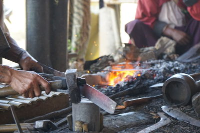 Cropped image of blacksmith working by fire