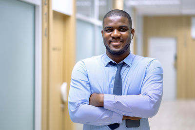 Portrait of young man standing at home