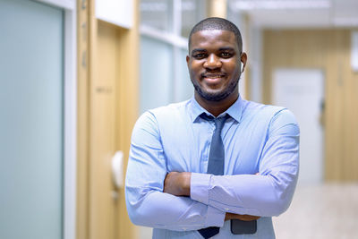 Portrait of young man standing at home