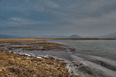 Scenic view of sea against cloudy sky