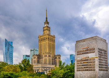 Low angle view of skyscrapers against cloudy sky