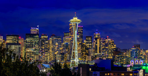 Illuminated cityscape against sky at night