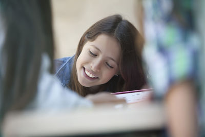 Portrait of a smiling young woman reading book