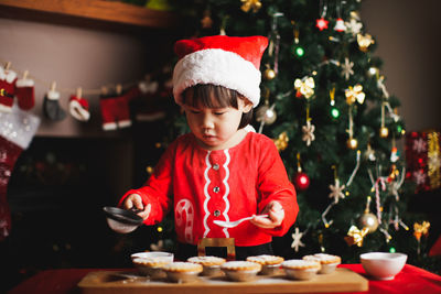 Girl preparing cookie at home during christmas