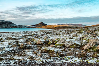 Scenic view of rocks on shore against sky
