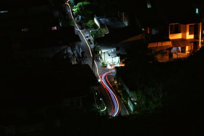 High angle view of light trails on road amidst buildings in city