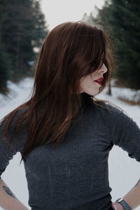 Woman standing on snow covered tree