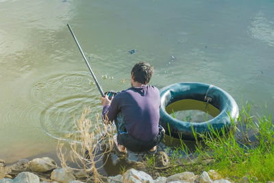 Rear view of boy floating on lake