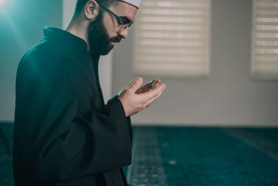 Side view of young man using mobile phone