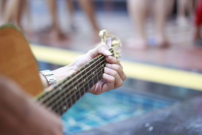 Cropped hand of woman playing guitar