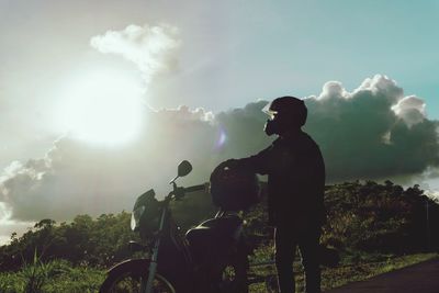 Rear view of man riding motorcycle against sky