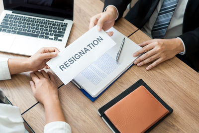 Midsection of man using mobile phone on table