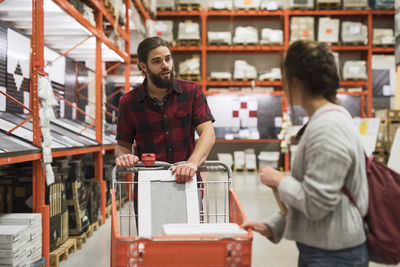 Couple looking at each other while shopping in hardware store