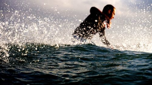 Man surfing in sea against sky