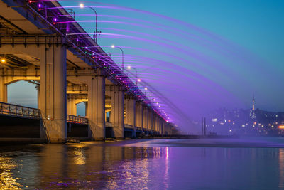 Bridge over river in city at night