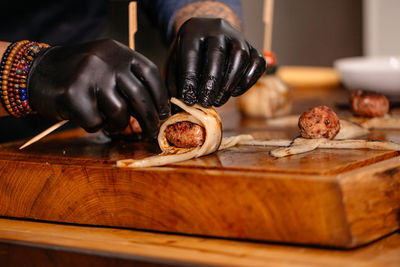 Cropped hand of person preparing food on table