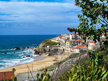 Scenic view of sea by buildings against sky