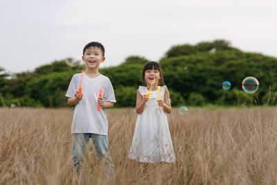 Portrait of happy boy standing on field