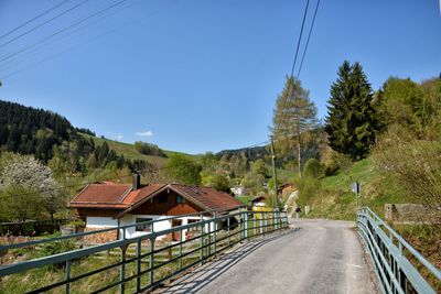 Houses by road against clear sky