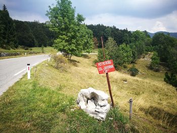 Information sign on field against sky