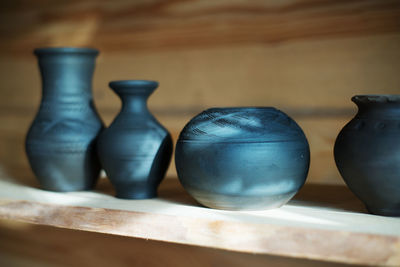 Close-up of pots on shelf at workshop