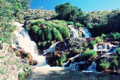 Scenic view of waterfall against sky