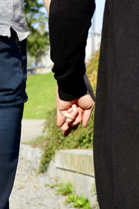 Midsection of couple holding hands