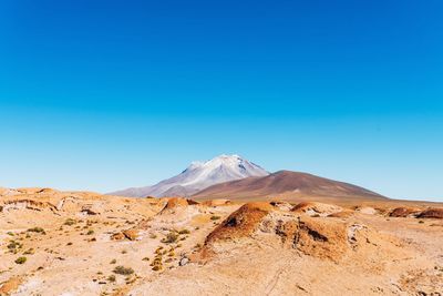 Scenic view of mountains against clear blue sky