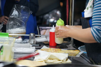 Midsection of preparing food on table at restaurant