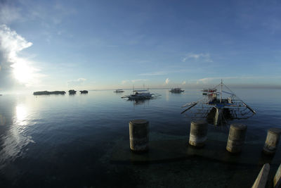 Sailboats in sea against sky